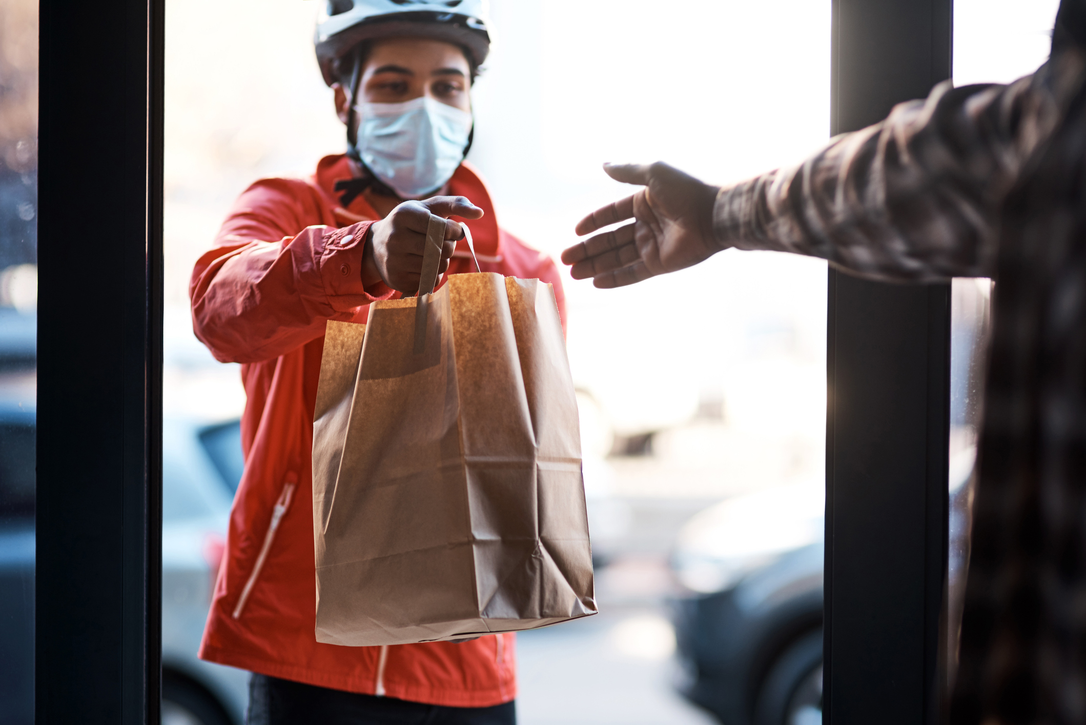 Delivery man delivering grocery bag wearing face mask and gloves